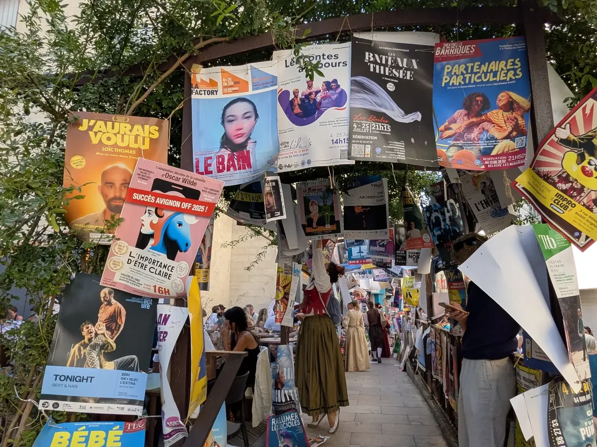 Passage couvert d’affiches du Festival Off dans une rue d’Avignon