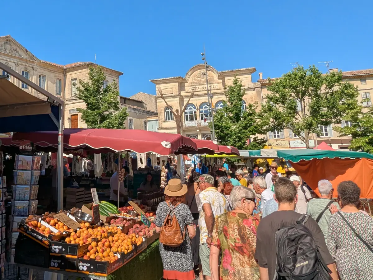 Shoppers and fruit stalls in the square in front of Apt’s town hall