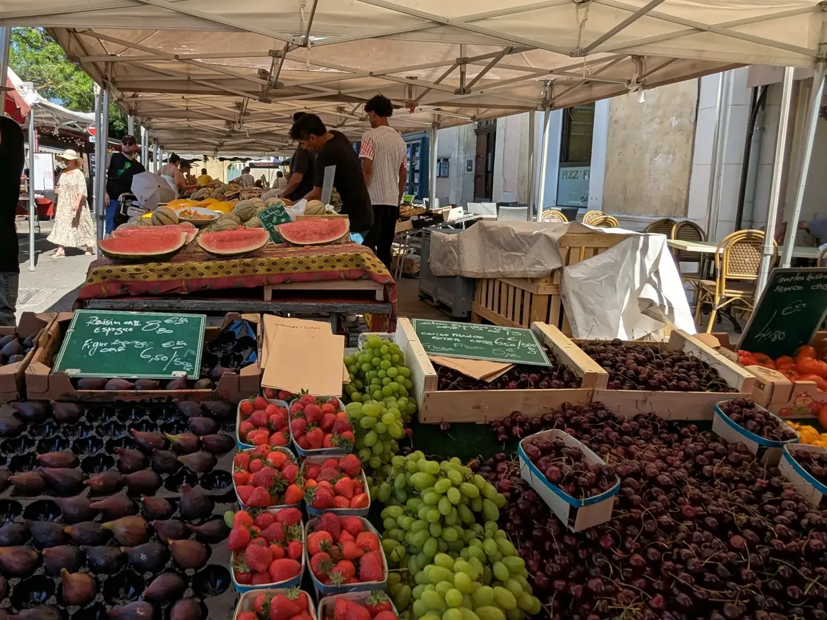 Obststand unter den Planen des Marktes von L’Isle-sur-la-Sorgue