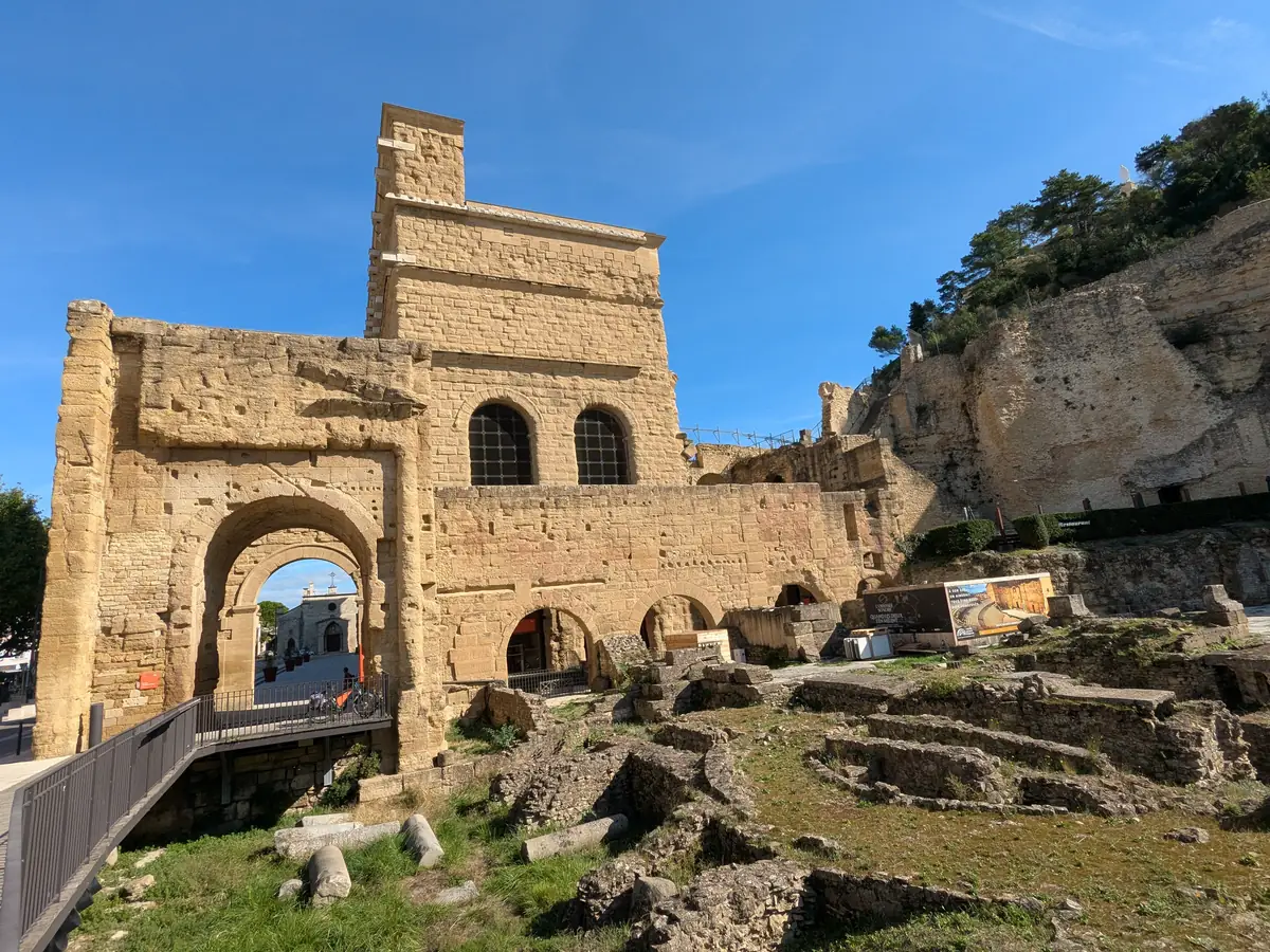 The temple remains in the foreground, with the buildings of the ancient theatre of Orange behind