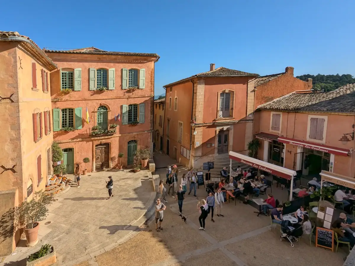 Roussillon town hall square lined with ochre façades and café terraces
