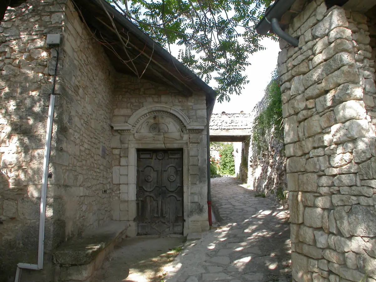 Passage couvert et porte sculptée dans une rue de Simiane-la-Rotonde