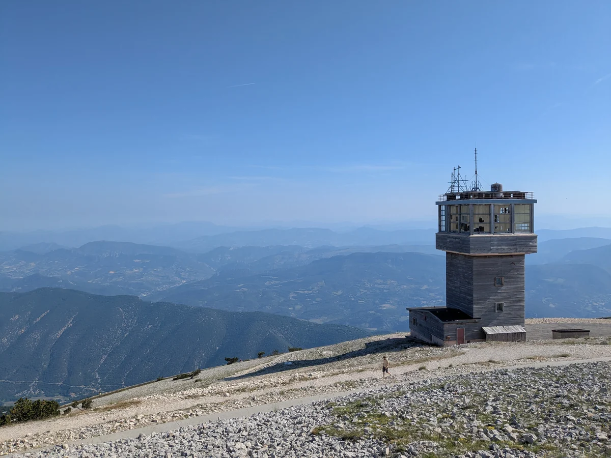 Petite tour sur une pente de pierres blanches devant des montagnes successives