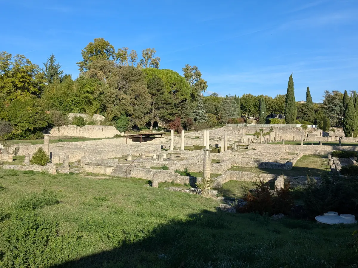 Gesamtansicht der Mauern und Säulenreihen der antiken Stätte La Villasse in Vaison-la-Romaine zwischen Bäumen