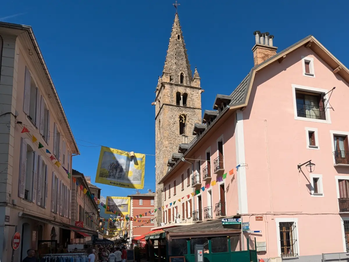 Papel picado bunting above a street in Barcelonnette, the Cardinalis tower behind